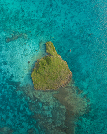 Aerial view of an island with vibrant green vegetation surrounded by turquoise waters Noumea New Caledonia. Aerial view of an island with vibrant green vegetation surrounded by turquoise waters Noumea New Caledonia.