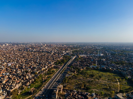 Aerial view of Minar e Pakistan and the surrounding dense urban landscape of Lahore featuring historic buildings a major road and clear blue sky in Lahore Punjab Pakistan.