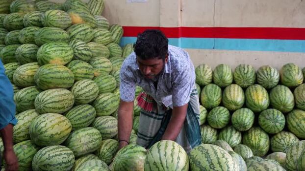 View of a worker with watermelons at Sadarghat Bangladesh.