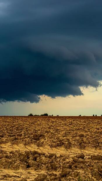 View of a plowed field under a dramatic stormy sky in Latvia. View of a plowed field under a dramatic stormy sky in Latvia.