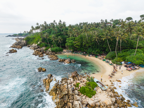 Aerial view of Secret Beach Mirissa featuring turquoise water rocky shoreline and lush palm trees Mirissa Southern Province Sri Lanka. Aerial view of Secret Beach Mirissa featuring turquoise water rocky shoreline and lush palm trees Mirissa Southern Province Sri Lanka.
