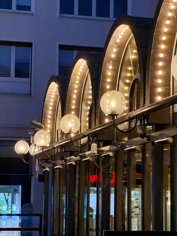 Hanover Germany 30 March 2026 View of the illuminated arched facade of a building in Hanover Germany featuring decorative globe lights and warm lighting at dusk.