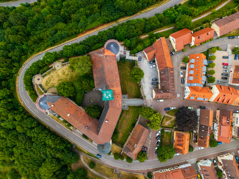 Aerial view of Schloss Waldenburg with its historic red tiled roofs surrounding lush green trees and nearby winding roads in the town center Waldenburg Sachsen Germany. Aerial view of Schloss Waldenburg with its historic red tiled roofs surrounding lush green trees and nearby winding roads in the town center Waldenburg Sachsen Germany.