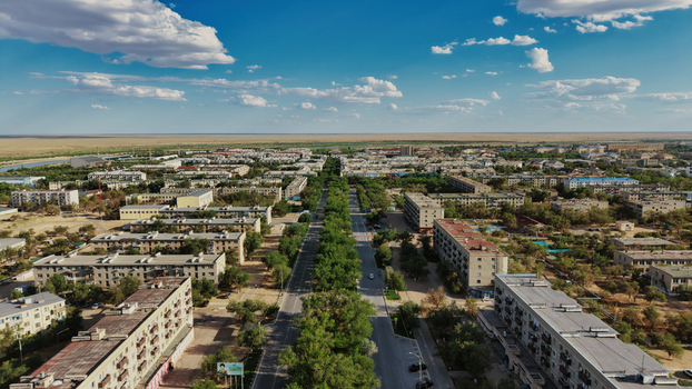 Aerial view of Baikonur Cosmodrome town with residential blocks a tree lined road and arid steppe landscape in Karmakshy District Kyzylorda Region Kazakhstan.