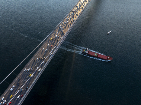 Aerial view of Fatih Sultan Mehmet Bridge with heavy traffic on the deck and a cargo ship passing underneath in the Bosphorus Beykoz Istanbul Turkey. Aerial view of Fatih Sultan Mehmet Bridge with heavy traffic on the deck and a cargo ship passing underneath in the Bosphorus Beykoz Istanbul Turkey.