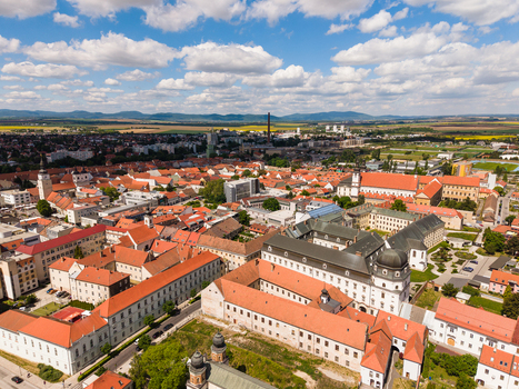 Aerial view of the historic city center with red roofed buildings church towers and university complexes under a blue sky with white clouds in Trnava Trnava Region Slovakia. Aerial view of the historic city center with red roofed buildings church towers and university complexes under a blue sky with white clouds in Trnava Trnava Region Slovakia.