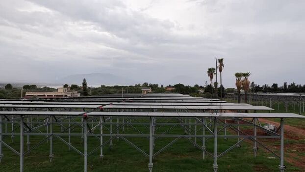 Aerial view of solar panel array in rural field Italy.