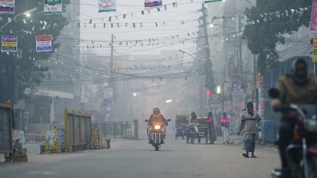 View of a foggy street with a motorcyclist in Bogura Bangladesh. View of a foggy street with a motorcyclist in Bogura Bangladesh.