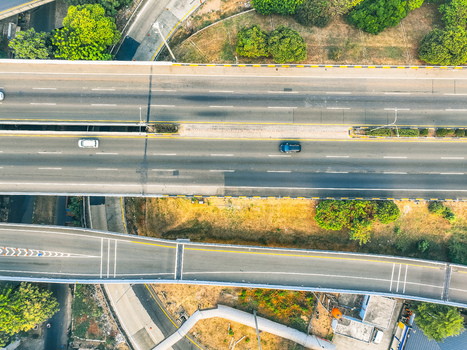 Aerial view of the Cikunir highway interchange with multi level roads moving cars and surrounding greenery in Kecamatan Bekasi Selatan Jawa Barat Indonesia. Aerial view of the Cikunir highway interchange with multi level roads moving cars and surrounding greenery in Kecamatan Bekasi Selatan Jawa Barat Indonesia.