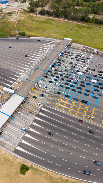 Aerial view of the Milano Sud toll plaza on the A1 motorway featuring heavy vehicle traffic highway infrastructure and transportation systems in Melegnano Lombardy Italy.
