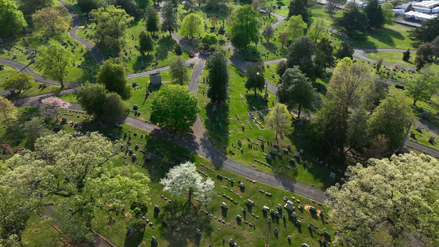Aerial view of a historic cemetery with winding paths lush green trees and numerous gravestones in Lynchburg Virginia United States.