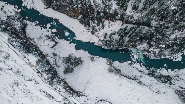 Aerial view of a turquoise river winding through a snow laden valley contrasting with the dark evergreens clinging to the steep slopes Sharda Azad Kashmir Pakistan. Aerial view of a turquoise river winding through a snow laden valley contrasting with the dark evergreens clinging to the steep slopes Sharda Azad Kashmir Pakistan.