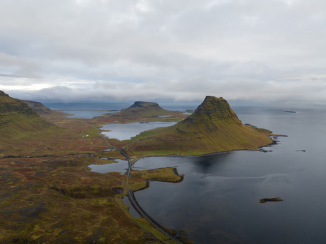 Aerial view of Kirkjufell mountain rising majestically from the sea its green slopes contrasting with the dark waters Grundarfjordur Iceland. Aerial view of Kirkjufell mountain rising majestically from the sea its green slopes contrasting with the dark waters Grundarfjordur Iceland.