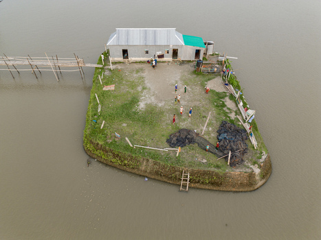 Mithamain Bangladesh 10 September 2025 Aerial view of a small house on a raised grassy plot surrounded by water with people and a bamboo bridge. Mithamain Bangladesh 10 September 2025 Aerial view of a small house on a raised grassy plot surrounded by water with people and a bamboo bridge.