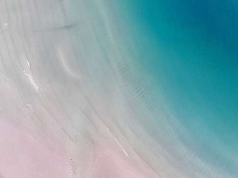 Aerial view of Gruinard Bay showing the sandy beach with ripple patterns meeting the turquoise water in Gruinard Scotland United Kingdom. Aerial view of Gruinard Bay showing the sandy beach with ripple patterns meeting the turquoise water in Gruinard Scotland United Kingdom.
