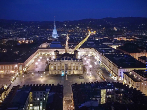 Aerial view of the illuminated Piazza Castello and Palazzo Madama at night with the Mole Antonelliana spire in the distance Turin Piedmont Italy.