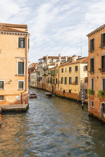 View of a canal lined with historic buildings and wooden boats in Venice Veneto Italy. View of a canal lined with historic buildings and wooden boats in Venice Veneto Italy.
