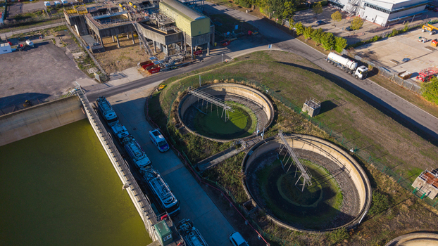 Aerial view of the Water Treatment Centre Camberley featuring circular sedimentation tanks industrial infrastructure and tanker trucks parked on site in Camberley England United Kingdom. Aerial view of the Water Treatment Centre Camberley featuring circular sedimentation tanks industrial infrastructure and tanker trucks parked on site in Camberley England United Kingdom.