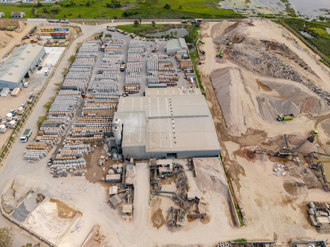 Aerial view of the Philippi industrial site with large piles of sand gravel conveyor belts a warehouse and rows of stacked materials in Cape Town Western Cape South Africa.