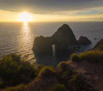 Aerial view of the Koganezaki Horse Rock formation and rugged coastline during a golden sunset over the ocean in Izu Shizuoka Japan. Aerial view of the Koganezaki Horse Rock formation and rugged coastline during a golden sunset over the ocean in Izu Shizuoka Japan.