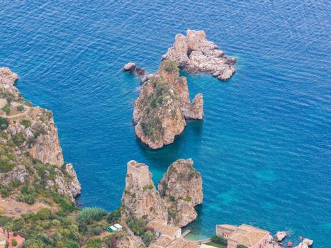 Aerial view of the rugged cliffs and sea stacks of Riserva Naturale Orientata dello Zingaro with clear blue water and coastal vegetation in San Vito Lo Capo Sicilia Italy. Aerial view of the rugged cliffs and sea stacks of Riserva Naturale Orientata dello Zingaro with clear blue water and coastal vegetation in San Vito Lo Capo Sicilia Italy.