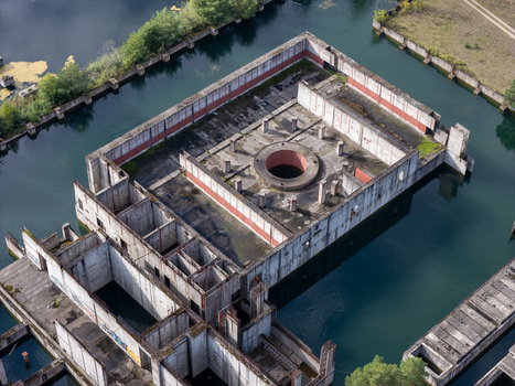 Aerial view of the unfinished Zarnowiec Nuclear Power Plant foundations surrounded by water featuring concrete structures and a central circular opening in Zarnowiec Poland. Aerial view of the unfinished Zarnowiec Nuclear Power Plant foundations surrounded by water featuring concrete structures and a central circular opening in Zarnowiec Poland.