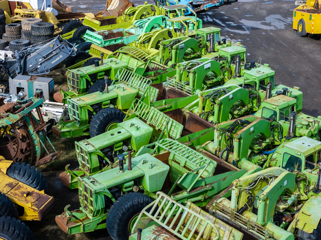 Woodburn Oregon United States 25 September 2026 Aerial view of rows of lime green construction scrapers parked in an industrial yard with large tires and heavy machinery visible. Woodburn Oregon United States 25 September 2026 Aerial view of rows of lime green construction scrapers parked in an industrial yard with large tires and heavy machinery visible.