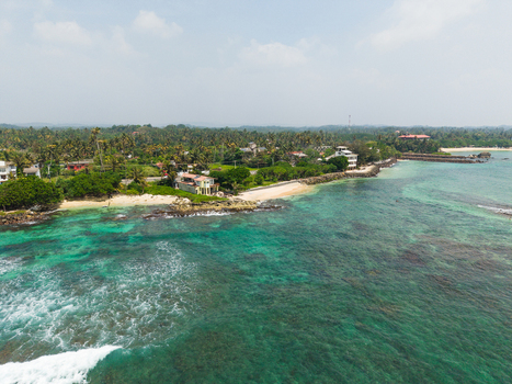 Aerial view of Devil s Rock and the tropical coastline with turquoise water coral reefs and sandy beaches in Ahangama Southern Province Sri Lanka. Aerial view of Devil s Rock and the tropical coastline with turquoise water coral reefs and sandy beaches in Ahangama Southern Province Sri Lanka.