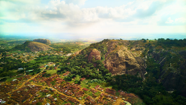 Aerial view of the rugged rocky landscape contrasting with the clustered buildings below all under a sky of scattered clouds Ibadan Nigeria. Aerial view of the rugged rocky landscape contrasting with the clustered buildings below all under a sky of scattered clouds Ibadan Nigeria.