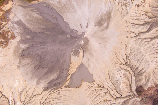 Aerial view of the Mud Volcanoes of Paclele Mari showing the unique grey mud formations intricate drainage patterns and barren landscape in Paclele Buzau County Romania.
