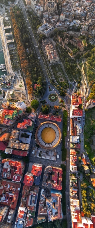 Aerial view of the historic Plaza de toros de La Malagueta bullring surrounded by urban buildings and the green Paseo del Parque boulevard in Malaga Andalusia Spain. Aerial view of the historic Plaza de toros de La Malagueta bullring surrounded by urban buildings and the green Paseo del Parque boulevard in Malaga Andalusia Spain.