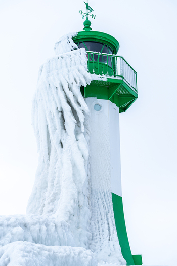 View of the Molenfeuer Sassnitz lighthouse covered in thick layers of ice and icicles during a cold winter day in Sassnitz Mecklenburg Vorpommern Germany.