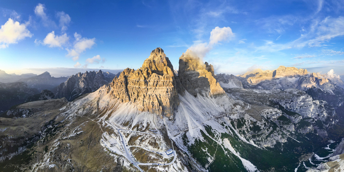 Aerial view of the majestic Tre Cime di Lavaredo peaks piercing the sky their rugged faces kissed by the sun s golden light Tre Cime di Lavaredo Belluno Italy. Aerial view of the majestic Tre Cime di Lavaredo peaks piercing the sky their rugged faces kissed by the sun s golden light Tre Cime di Lavaredo Belluno Italy.