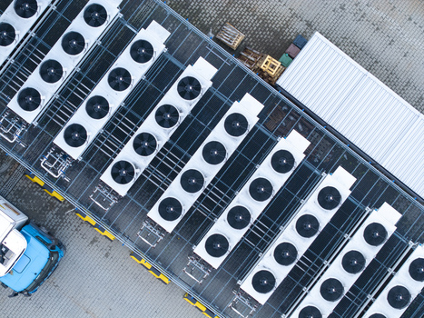 Aerial view of an industrial cooling system for a data center with rows of large fans on a rooftop next to a blue truck in Krakow Lesser Poland Voivode Poland. Aerial view of an industrial cooling system for a data center with rows of large fans on a rooftop next to a blue truck in Krakow Lesser Poland Voivode Poland.