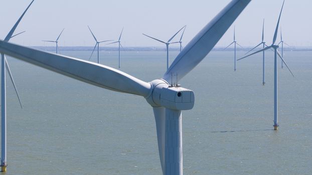 Aerial view of Windpark Fryslan offshore wind turbines standing in the water under a clear blue sky in Breezanddijk Friesland Netherlands. Aerial view of Windpark Fryslan offshore wind turbines standing in the water under a clear blue sky in Breezanddijk Friesland Netherlands.