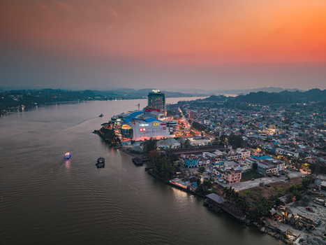 Samarinda Indonesia 19 September 2026 Aerial view of Big Mall Samarinda situated along the Mahakam River at sunset with urban buildings boats on the water and a warm orange sky. Samarinda Indonesia 19 September 2026 Aerial view of Big Mall Samarinda situated along the Mahakam River at sunset with urban buildings boats on the water and a warm orange sky.