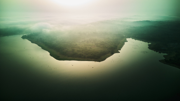 Aerial view of Owala Dam surrounded by dense vegetation and mist during golden hour in Osogbo Osun Nigeria. Aerial view of Owala Dam surrounded by dense vegetation and mist during golden hour in Osogbo Osun Nigeria.