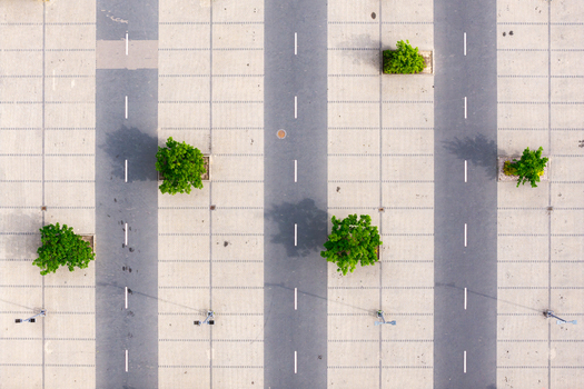 Aerial view of a paved parking lot with white lane markings and green trees in planters in Warsaw Masovian Voivodeship Poland. Aerial view of a paved parking lot with white lane markings and green trees in planters in Warsaw Masovian Voivodeship Poland.