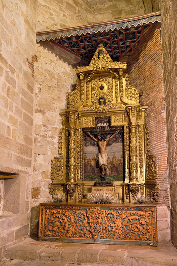 Plasencia Spain 03 December 2025 View of the ornate gilded altarpiece with a crucifix inside the Catedral Nueva de Plasencia featuring intricate golden carvings and stone walls. Plasencia Spain 03 December 2025 View of the ornate gilded altarpiece with a crucifix inside the Catedral Nueva de Plasencia featuring intricate golden carvings and stone walls.