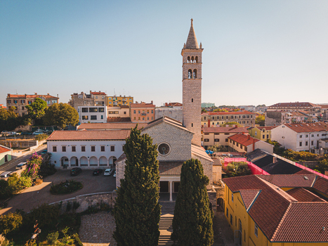 Aerial view of the Cathedral in Pula with its weathered stone facade and towering bell tower standing proudly amidst the terracotta rooftops and sun drenched streets Pula Istria County Croatia.