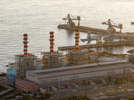 Aerial view of Centrale Termoelettrica Torrevaldaliga Nord power plant with tall chimneys industrial buildings and harbor cranes along the coastline in Civitavecchia Lazio Italy. Aerial view of Centrale Termoelettrica Torrevaldaliga Nord power plant with tall chimneys industrial buildings and harbor cranes along the coastline in Civitavecchia Lazio Italy.