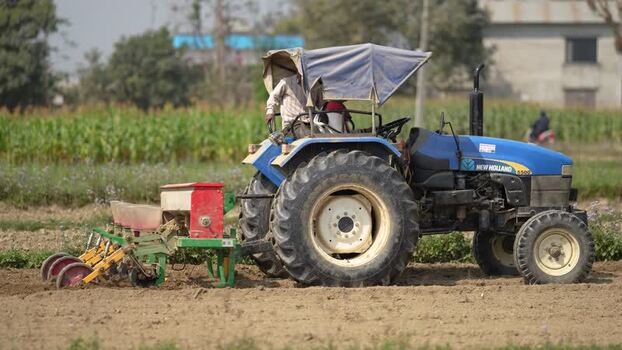 View of a farmer operating a tractor in a field in Dhangadhi Nepal. View of a farmer operating a tractor in a field in Dhangadhi Nepal.