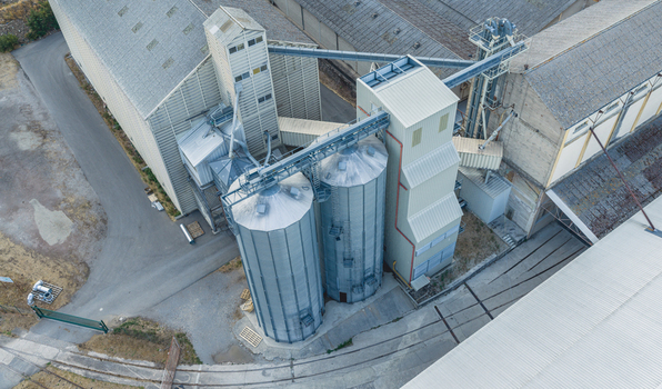 Aerial view of grain silos and conveyor systems at an industrial agricultural facility in Le Pouzin Auvergne Rhone Alpes France.