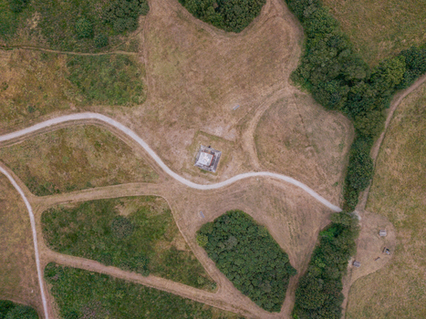 Aerial view of the Bodmin Beacon monument surrounded by grassy fields walking paths and patches of trees in Bodmin Cornwall United Kingdom. Aerial view of the Bodmin Beacon monument surrounded by grassy fields walking paths and patches of trees in Bodmin Cornwall United Kingdom.