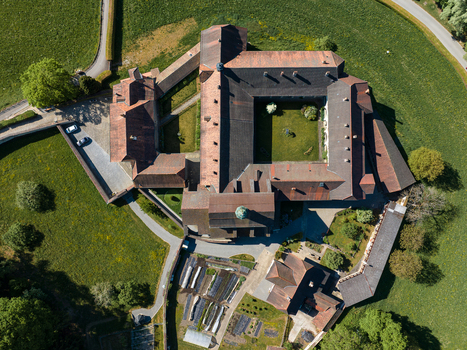 Aerial view of La Maigrauge Abbey featuring historic stone buildings with red tiled roofs a central courtyard and lush green gardens in Fribourg Fribourg Switzerland. Aerial view of La Maigrauge Abbey featuring historic stone buildings with red tiled roofs a central courtyard and lush green gardens in Fribourg Fribourg Switzerland.