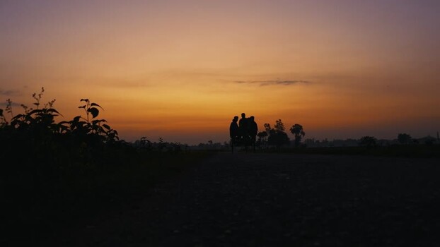 View of people on a rickshaw at sunset in Bogura Bangladesh. View of people on a rickshaw at sunset in Bogura Bangladesh.