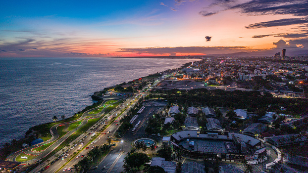 Aerial view of Feria Ganadera along the coastline at sunset featuring the coastal highway urban skyline and the Caribbean Sea in Santo Domingo Distrito Nacional Dominican Republic. Aerial view of Feria Ganadera along the coastline at sunset featuring the coastal highway urban skyline and the Caribbean Sea in Santo Domingo Distrito Nacional Dominican Republic.