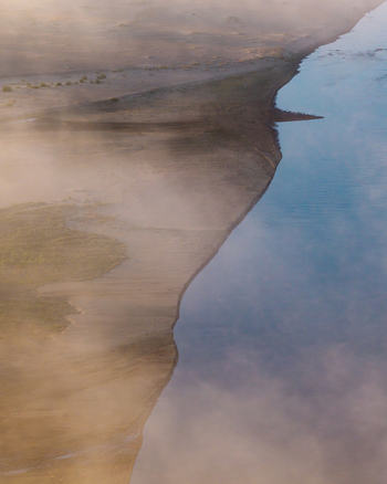 Aerial view of Zawadowskie Islands Nature Reserve with sandy riverbanks and mist over the Vistula river in Warsaw Masovian Voivodeship Poland.