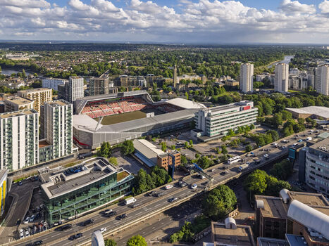 Aerial view of the Gtech Community Stadium surrounded by modern residential buildings urban infrastructure and lush greenery in Brentford England United Kingdom. Aerial view of the Gtech Community Stadium surrounded by modern residential buildings urban infrastructure and lush greenery in Brentford England United Kingdom.