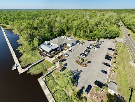 Aerial view of a restaurant with a parking lot full of cars next to a river with a road surrounded by trees St. Augustine Florida United States. Aerial view of a restaurant with a parking lot full of cars next to a river with a road surrounded by trees St. Augustine Florida United States.